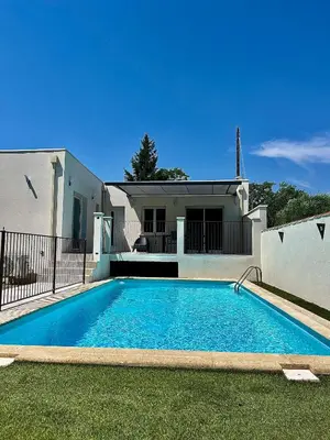 a swimming pool in front of a house at Le Cabanon Meublé de Tourisme trois étoiles in Entraigues-sur-la-Sorgue