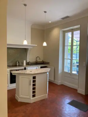 a kitchen with a white island in a room at La Suite Gregoire in Apt