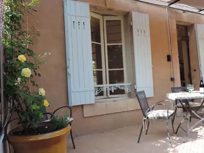 a patio with a table and chairs and a window at La Suite Gregoire in Apt