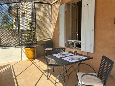 a patio with a table and chairs on a balcony at La Suite Gregoire in Apt