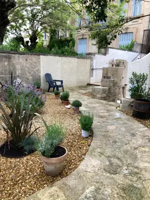 a garden with potted plants and a bench at La Suite Gregoire in Apt
