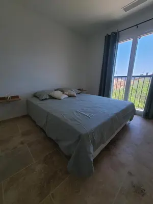 a bedroom with a bed and a large window at le petit 105 villa neuve avec piscine in La Fare-les-Oliviers