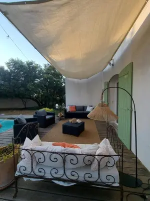 a living room with a couch and a patio at le petit 105 villa neuve avec piscine in La Fare-les-Oliviers