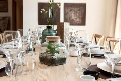 a table with glasses and a jar with flowers in it at Villa Les Escapades d'Adrien, piscine, climatisation in Sannes