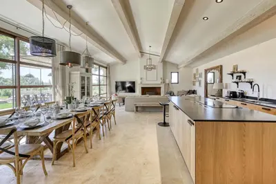 a kitchen and dining room with a long table and chairs at Villa Les Escapades d'Adrien, piscine, climatisation in Sannes