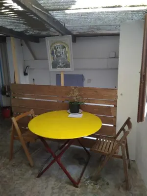 a yellow table with two chairs and a bench at Tranquility of Lub in this duplex in La Bastide-des-Jourdans