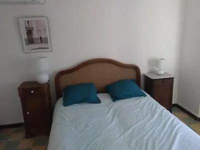 a bed with two blue pillows and two night stands at Tranquility of Lub in this duplex in La Bastide-des-Jourdans