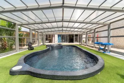 a swimming pool in a house with an open ceiling at Le logis de la castagne in Caumont-sur-Durance