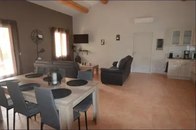 a living room with a table and chairs at les lauriers in Caromb