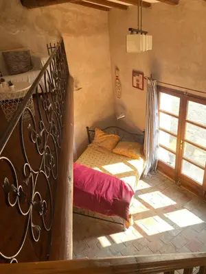 a bedroom with a bed and a staircase in a room at Maison typique provençale au calme absolu dans le triangle d or a Bonnieux in Bonnieux