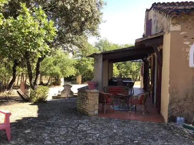 a patio with a table and chairs in a yard at Maison typique provençale au calme absolu dans le triangle d or a Bonnieux in Bonnieux