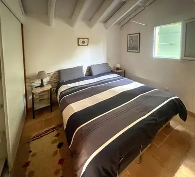 a large bed in a bedroom with a window at La maison de l'olivier in Saint-Saturnin-les-Apt