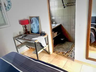 a room with a mirror and a desk with a table sidx sidx sidx at La maison de l'olivier in Saint-Saturnin-les-Apt