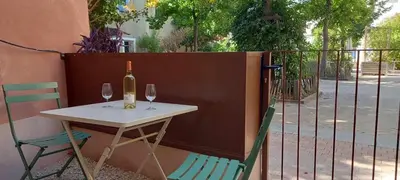 a table with a bottle of wine and two glasses at Place ô sorgue ! in LʼIsle-sur-la-Sorgue