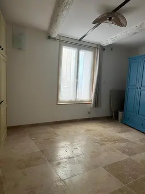 an empty room with a ceiling fan and a window at Place ô sorgue ! in LʼIsle-sur-la-Sorgue