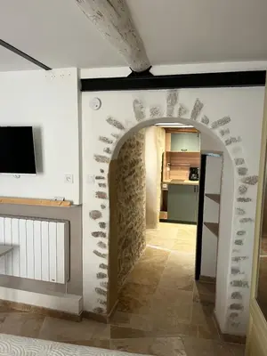 a hallway with an archway in a room with a kitchen at Place ô sorgue ! in LʼIsle-sur-la-Sorgue
