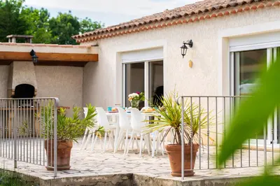 a patio of a house with white chairs and a table at Villa & Piscine 8P entre Isle sur Sorgue et Avignon in Caumont-sur-Durance