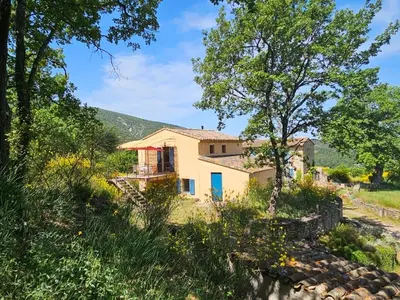 a house in the middle of a field with trees at Vues imprenables, calme, nature, confort in Bonnieux