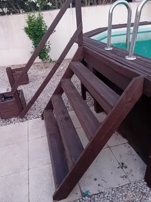 a wooden bench next to a swimming pool at Provencal-style villa in Morières-lès-Avignon