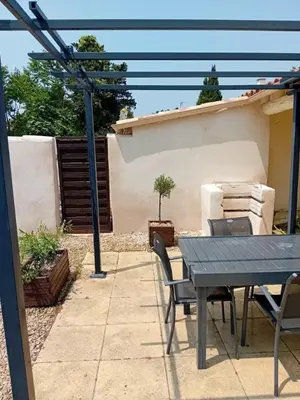 a picnic table and chairs in a backyard with a house at Provencal-style villa in Morières-lès-Avignon