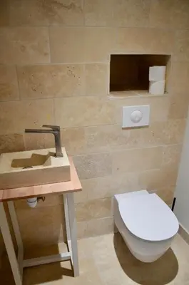 a bathroom with a toilet and a sink at La Serre in Viens