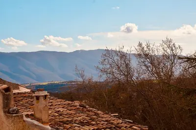 a roof of a house with mountains in the background at La Serre in Viens