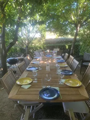 a long wooden table with plates and glasses on it at beautiful 4 bedroom villa, pool, Luberon in Cadenet