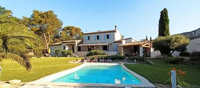 a house with a swimming pool in front of a yard at le mas du luberon rouge in Cheval-Blanc