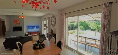 a living room with a dining room table and a view of a patio at le mas du luberon rouge in Cheval-Blanc