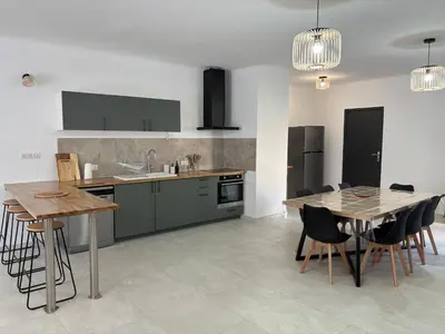 a kitchen with green cabinets and a table and chairs at Appartement 100 m carré pour 6 à 8 personnes in Saint-Cannat