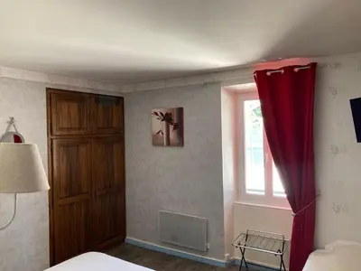 a bedroom with a red curtain and a window at Hotel D'Albion in Sault-de-Vaucluse