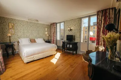 a bedroom with a bed and a desk and a television at La Bastide de Paula in Aix-en-Provence