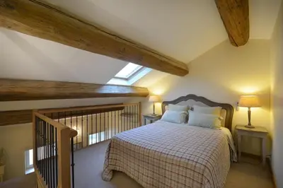 a bedroom with a bed with a checkered blanket at Le moulin vieux, mas authentique en Provence avec piscine in Entraigues-sur-la-Sorgue