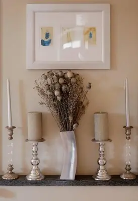 a vase with flowers and candles on a shelf at Le moulin vieux, mas authentique en Provence avec piscine in Entraigues-sur-la-Sorgue