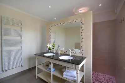 a bathroom with two sinks and a large mirror at Le moulin vieux, mas authentique en Provence avec piscine in Entraigues-sur-la-Sorgue
