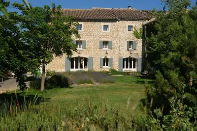 a large stone house with a large yard at Le moulin vieux, mas authentique en Provence avec piscine in Entraigues-sur-la-Sorgue