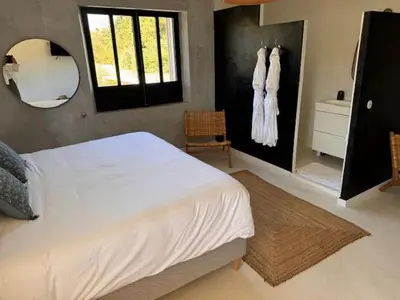 a bedroom with a large white bed and a mirror at Coeur des Hommes in Le Thor