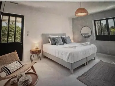a bedroom with a bed and a chair and a mirror at Coeur des Hommes in Le Thor