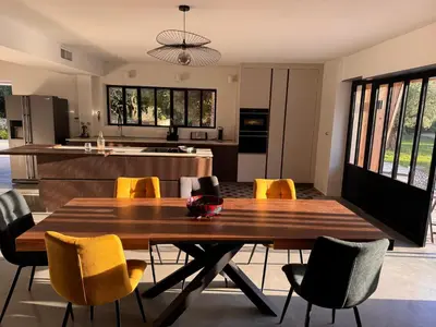 a kitchen with a wooden table and yellow chairs at Coeur des Hommes in Le Thor