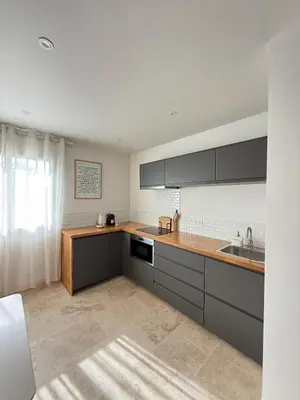 a kitchen with black cabinets and a sink at Charmants duplex , Clim et Piscine in Aix-en-Provence