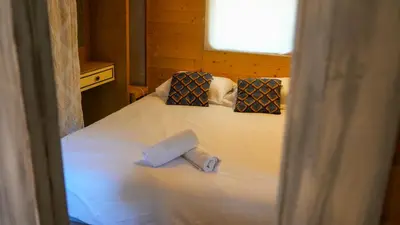 a bed with two pillows and a roll on it at La cabane - Nature et Spa in Aurons