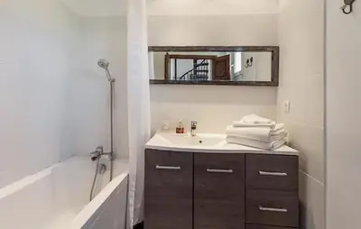 a bathroom with a sink and a tub and a mirror at Maison Avec Jacuzzi in Mazan