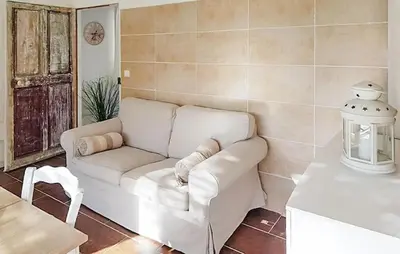 a living room with a white couch and a table at Maison Avec Jacuzzi in Mazan