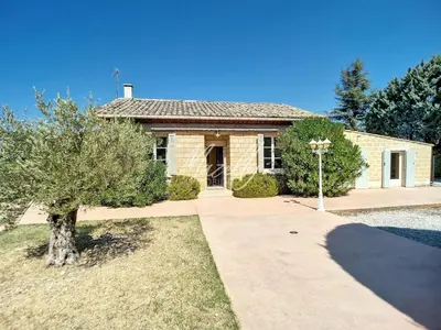 a brick house with a tree in front of it at La Villa Luberonnaise in Robion en Luberon
