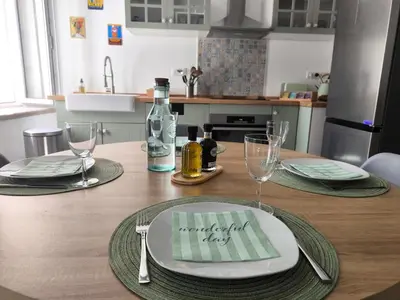 a table with plates and glasses and a bottle of wine at Maison au coeur de Banon in Banon