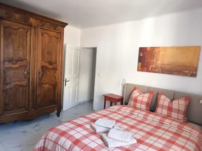 a bedroom with a red and white checkered bed at Maison au coeur de Banon in Banon