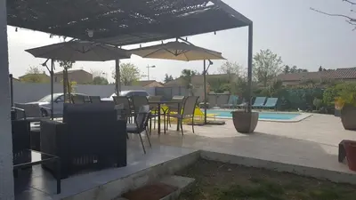 a patio with tables and chairs and umbrellas at Beautiful Villa Pool in Provence in Monteux