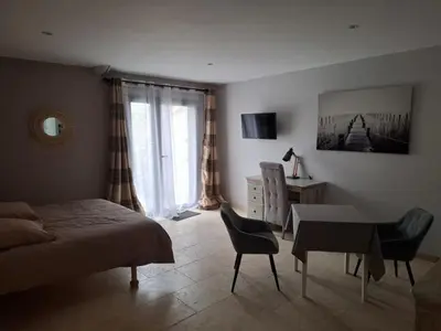 a bedroom with a bed and a table and chairs at logement indépendant avec terrasse privative dans les Alpilles in Aureille