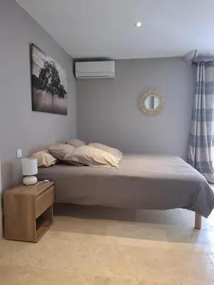 a bedroom with a large bed with a nightstand and a bed sidx sidx sidx at logement indépendant avec terrasse privative dans les Alpilles in Aureille