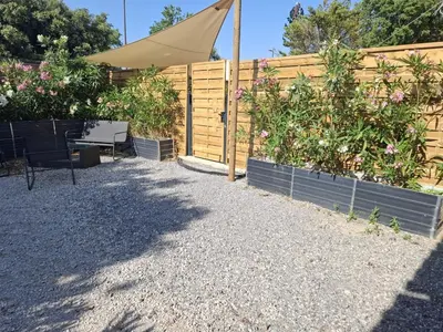 a garden with a fence and a bench and flowers at logement indépendant avec terrasse privative dans les Alpilles in Aureille